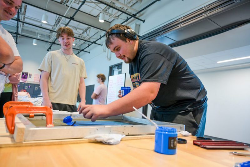 A student weatring headphones working on an art project 